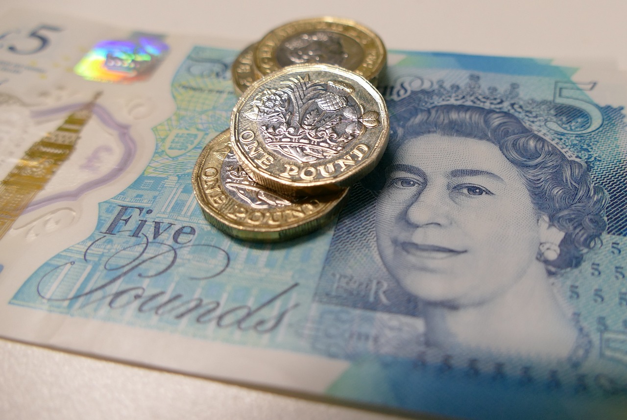 A £5 note with 4 £1 coins on top