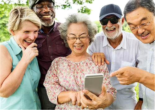 A group of older people, looking at a mobile phone