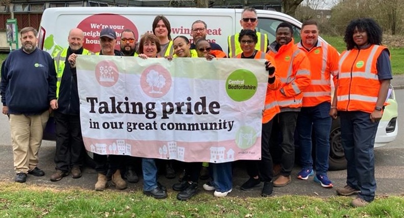 The Meadow Way clean-up crew, standing next to one of our vans. They're holder a banner which reads "Taking pride in our great community".