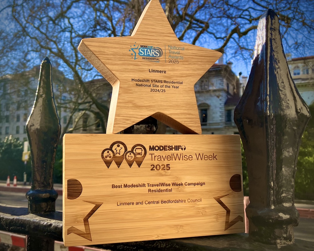The TravelWise Week Modeshift award 2025. It's a wooden trophy with a star on the top, engraved with the winners' details.